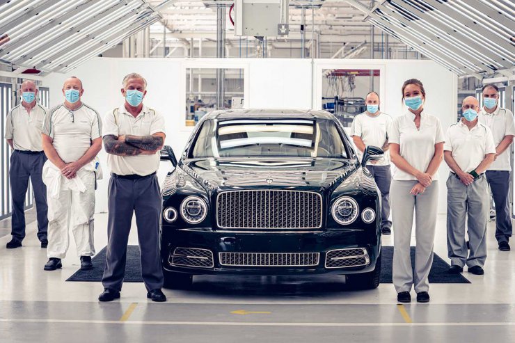 نمای جلو سدان بنتلی مولسان / bentley mulsanne با چراغ های گرد و جلوپنجره عریض و میله های عمودی و کارگران کارخانه