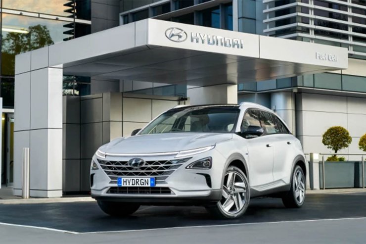 خودروی هیدروژنی / hydrogen car هیوندای نکسو / hyundai nexo سفید رنگ در کنار ساختمان با آرم هیوندای