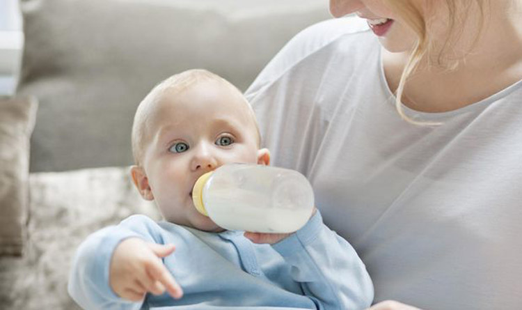 نوزاد در حال خوردن شیر خشک در آغوش مادر