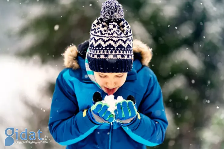 پسر بچه‌ای در حال برف خوردن