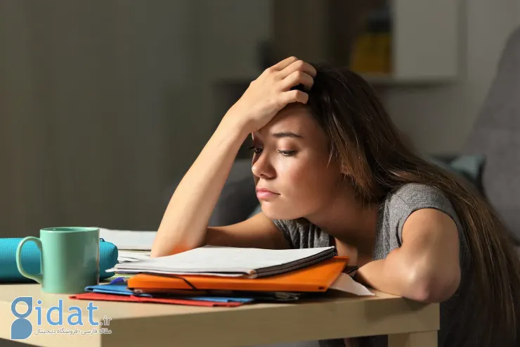 نگاه خسته دختر نوجوان به کتاب های درسی