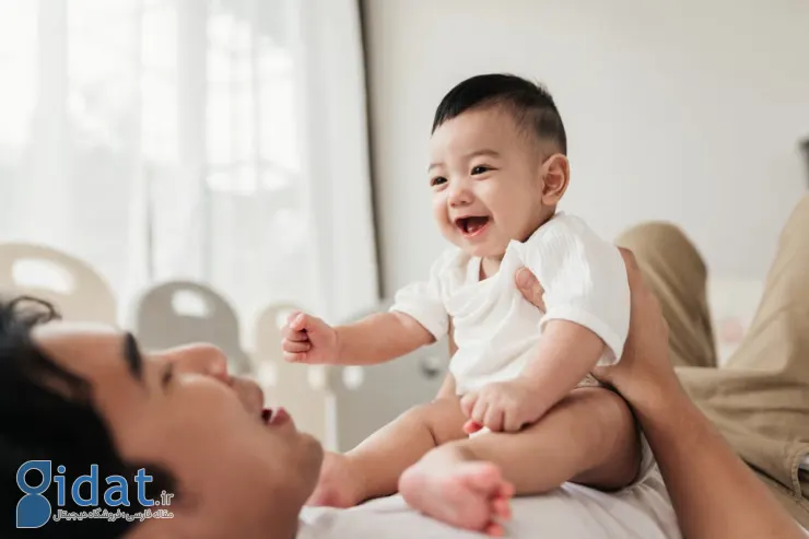 کودک نشسته روی شکم پدر آسیایی